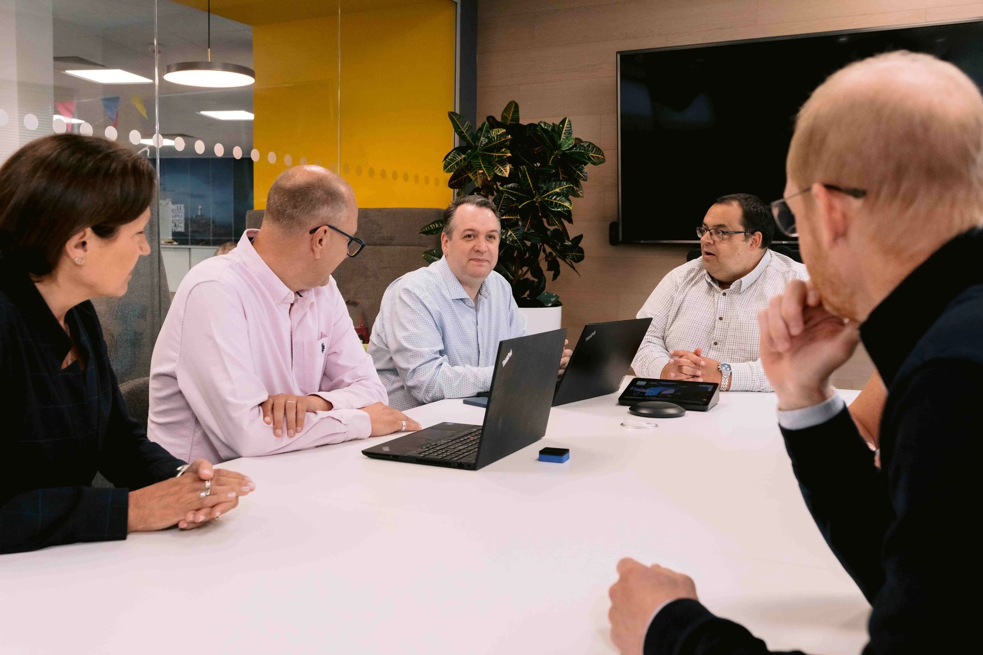 A group of male colleagues talk in a boardroom