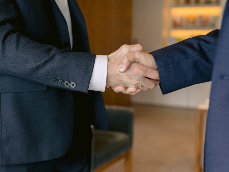 Business deal handshake representing a private and confidential M&A transaction