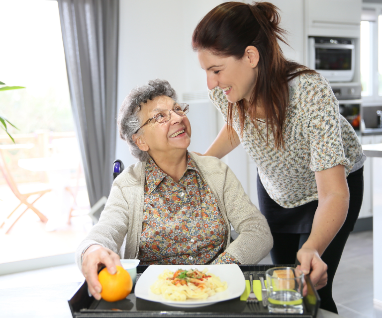 Home carer supporting an older client at home in Eastbourne, East Sussex