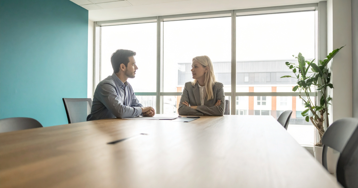 Two colleagues in tense discussion across an office desk, representing cultural mismatch risk in M&A acquisition execution
