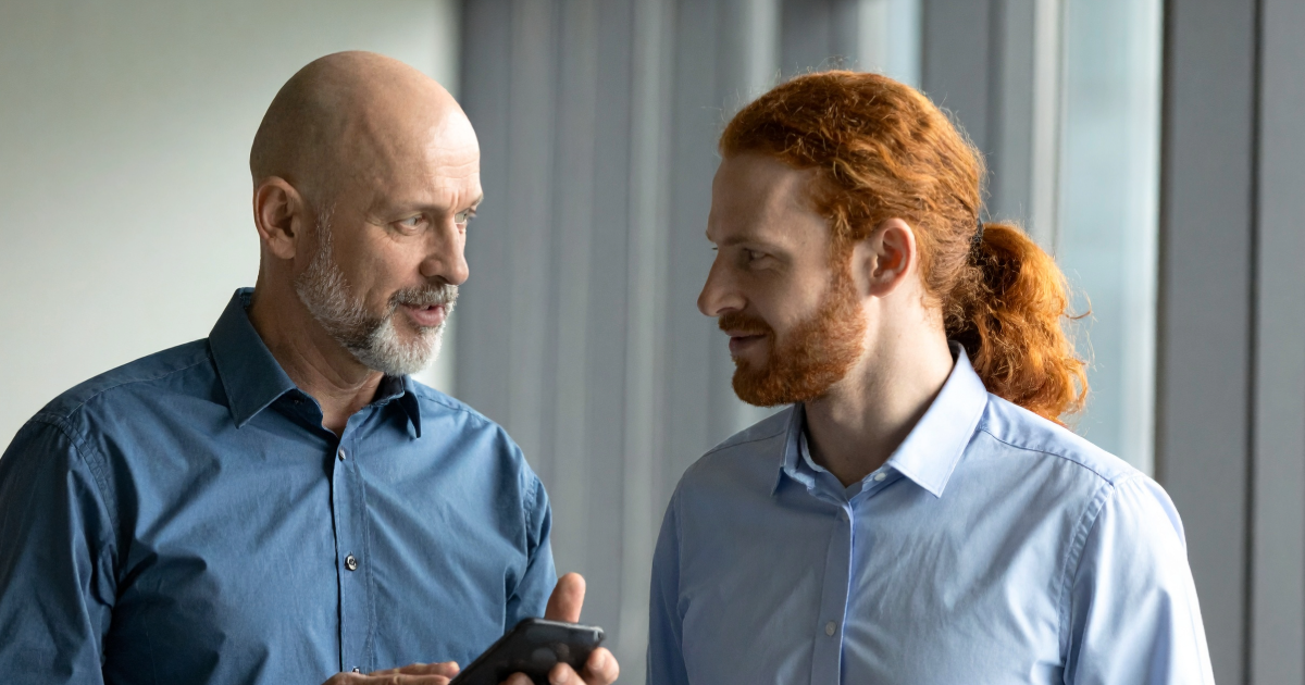A founder in a softly lit office delegating responsibility to a member of their senior team.